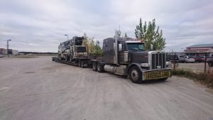 pumpcrete being hauled on lowbed in manitoba